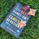 The Very Best Hands On Kinda Dangerous Family Devotions Book laying on the grass